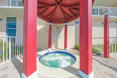 a pool in the middle of a building with red columns at Stunning Ocean & Sunset Views, Direct Beach Access with 2 King Bedrooms at Panama City Beach, Fl in Panama City Beach