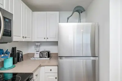 a refrigerator in a kitchen with white cabinets at Stunning Ocean & Sunset Views, Direct Beach Access with 2 King Bedrooms at Panama City Beach, Fl in Panama City Beach