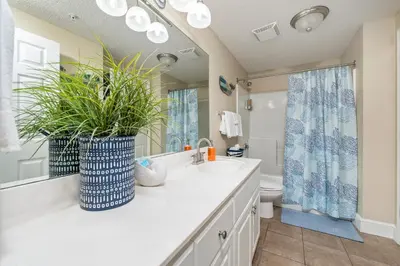 a bathroom with a sink and a toilet and a mirror at Stunning Ocean & Sunset Views, Direct Beach Access with 2 King Bedrooms at Panama City Beach, Fl in Panama City Beach