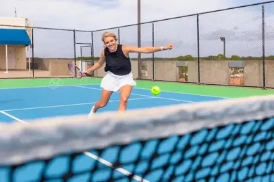 a woman hitting a tennis ball on a tennis court at Stunning Ocean & Sunset Views, Direct Beach Access with 2 King Bedrooms at Panama City Beach, Fl in Panama City Beach