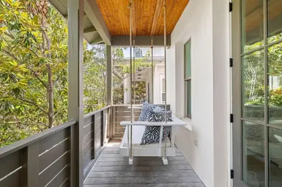a porch with a table and chairs on it at Found My Zen in Rosemary Beach
