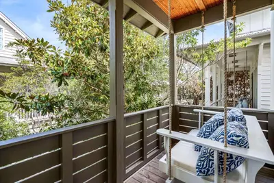 a porch with a bench on a wooden deck at Found My Zen in Rosemary Beach