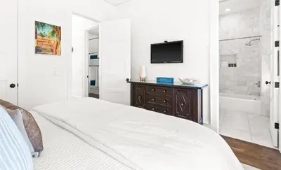 a bedroom with a bed and a tub and a television at Found My Zen in Rosemary Beach