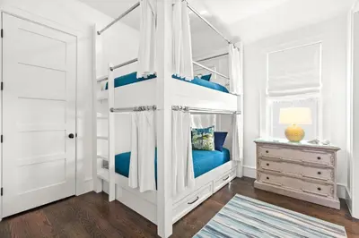 a bedroom with a bunk bed with blue sheets at Found My Zen in Rosemary Beach