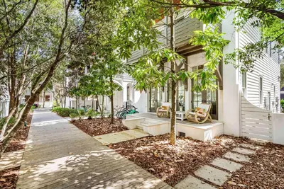 a white house with trees and a sidewalk at Found My Zen in Rosemary Beach