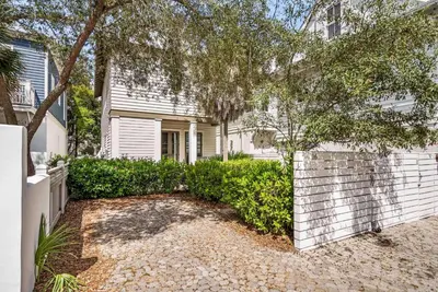a white house with a tree and a fence at Found My Zen in Rosemary Beach