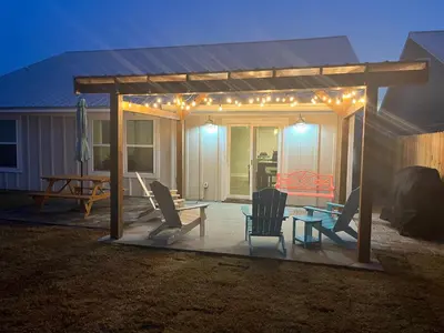 a gazebo with chairs and a table and lights at Coral Cabana - 3BD 2BA Home Close to Beach w/ optional Golf Cart! in Panama City Beach