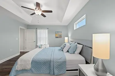 a bedroom with a bed and a ceiling fan at Coral Cabana - 3BD 2BA Home Close to Beach w/ optional Golf Cart! in Panama City Beach