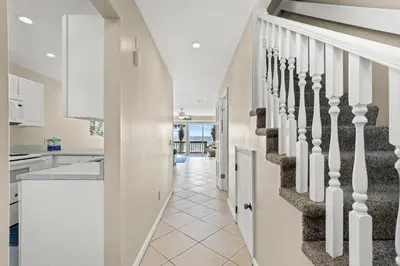 a hallway of a home with stairs and a kitchen at 2BD/25BA Gulf Front Townhome near Pier Park! Gulf Views! Beach Access! in Panama City Beach