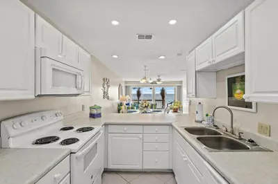 a white kitchen with white appliances and a sink at 2BD/25BA Gulf Front Townhome near Pier Park! Gulf Views! Beach Access! in Panama City Beach