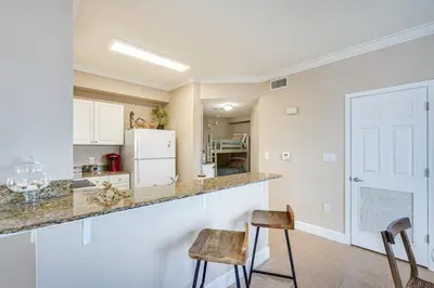 a kitchen with a counter and two stools at Panama City Beach Condo Balcony with Ocean Views! in Panama City Beach