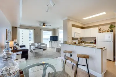 a kitchen and living room with a table and chairs at Panama City Beach Condo Balcony with Ocean Views! in Panama City Beach