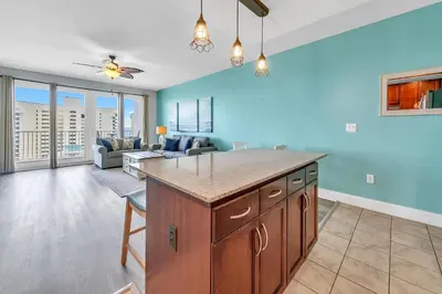 a kitchen and living room with blue walls at Laketown Wharf 607 in Panama City Beach