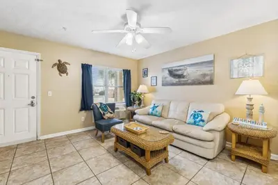 a living room with a couch and a ceiling fan at Merrimac Resort #31 in Panama City Beach