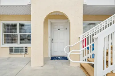 a white front door of a house with a staircase at Merrimac Resort #31 in Panama City Beach