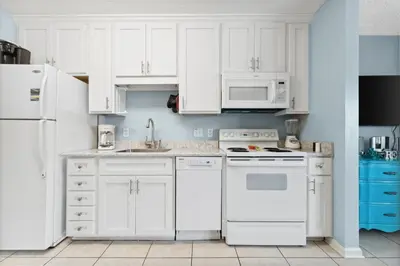 a white kitchen with white appliances and white cabinets at Merrimac Resort #41 in Panama City Beach