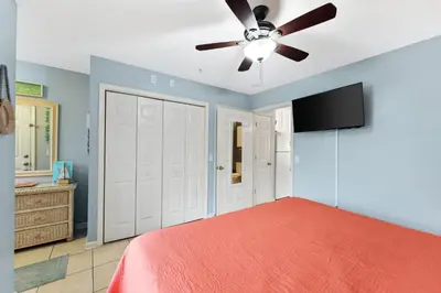 a bedroom with a bed and a ceiling fan at Merrimac Resort #41 in Panama City Beach
