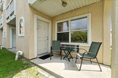 a patio with two chairs and a table in front of a house at Merrimac Resort #41 in Panama City Beach