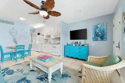 a living room with blue walls and a ceiling fan at Merrimac Resort #41 in Panama City Beach