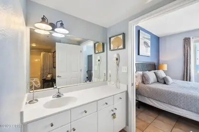 a bathroom with a sink and a bed and a mirror at Updated Beach Condo at the Shores of Panama Condos - Unit 918 in Panama City Beach