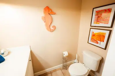 a bathroom with a toilet and a seahorse on the wall at Updated Beach Condo at the Shores of Panama Condos - Unit 918 in Panama City Beach