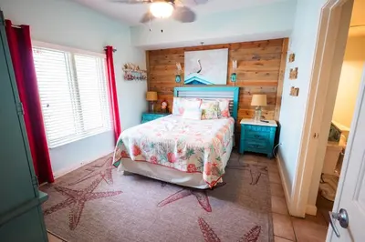 a bedroom with a bed and a wooden wall at Updated Beach Condo at the Shores of Panama Condos - Unit 918 in Panama City Beach