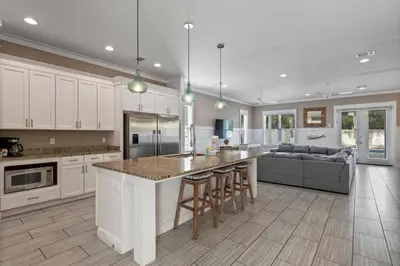 a kitchen and living room with a counter and a couch at Waves in Santa Rosa Beach