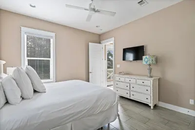 a bedroom with a white bed and a television at Waves in Santa Rosa Beach