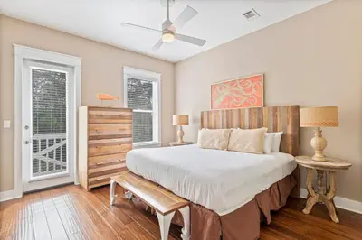 a bedroom with a large bed and two windows at Waves in Santa Rosa Beach