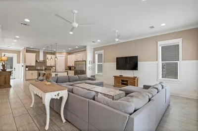 a living room with a large couch and a kitchen at Waves in Santa Rosa Beach