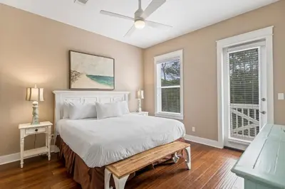 a bedroom with a bed and two windows at Waves in Santa Rosa Beach