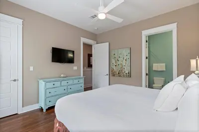 a bedroom with a white bed and a blue dresser at Waves in Santa Rosa Beach