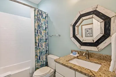 a bathroom with a sink and a toilet and a mirror at Waves in Santa Rosa Beach