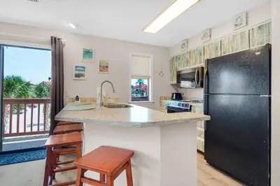 a kitchen with a black refrigerator and a counter top at St Thomas Square Villa 1211C Beach Bumz in Panama City Beach