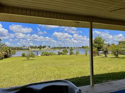 a view of a lake from the porch of a house at Nautical Nirvana-Waterfront Joys from Sunrise Paddles to Hot Tub Sunsets in Panama City