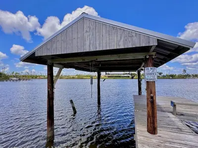 a building on a dock on a body of water at Nautical Nirvana-Waterfront Joys from Sunrise Paddles to Hot Tub Sunsets in Panama City