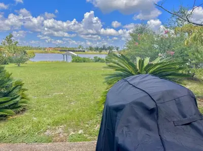 a tent sitting in a field next to a body of water at Nautical Nirvana-Waterfront Joys from Sunrise Paddles to Hot Tub Sunsets in Panama City