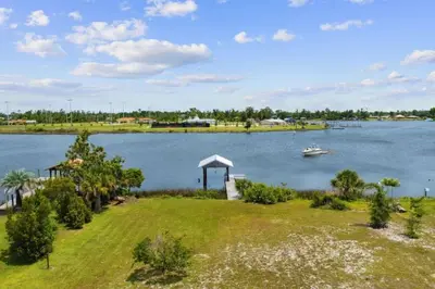 a boat on a lake with a gazebo at Nautical Nirvana-Waterfront Joys from Sunrise Paddles to Hot Tub Sunsets in Panama City