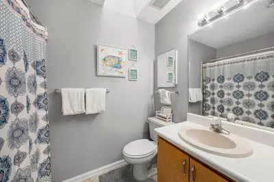 a bathroom with a sink and a toilet and a shower at Barefoot Bungalow in Panama City Beach