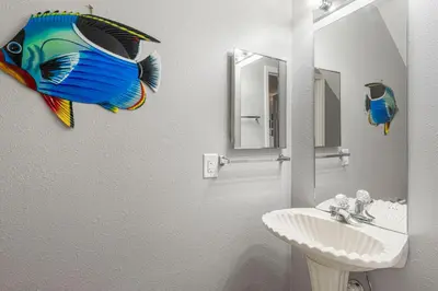 a bathroom with a fish on the wall next to a sink at Barefoot Bungalow in Panama City Beach