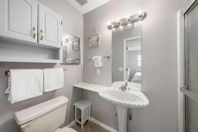 a white bathroom with a sink and a toilet at Barefoot Bungalow in Panama City Beach