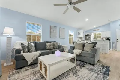 a living room with a couch and a table at March Sale! Walk to Beach - Large Private Yard - Fire Pit - Dog Friendly in Panama City Beach