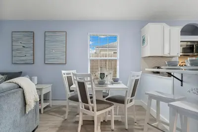 a kitchen and dining room with a table and chairs at March Sale! Walk to Beach - Large Private Yard - Fire Pit - Dog Friendly in Panama City Beach