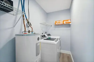 a small white laundry room with a washer and dryer at March Sale! Walk to Beach - Large Private Yard - Fire Pit - Dog Friendly in Panama City Beach