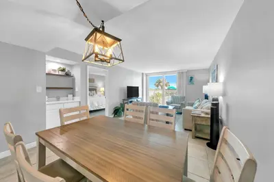 a dining room and living room with a table and chairs at BeachCrest 101 - Directly on the beach in the heart of Seagrove Beach along 30A in Santa Rosa Beach