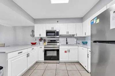 a white kitchen with white cabinets and appliances at BeachCrest 101 - Directly on the beach in the heart of Seagrove Beach along 30A in Santa Rosa Beach