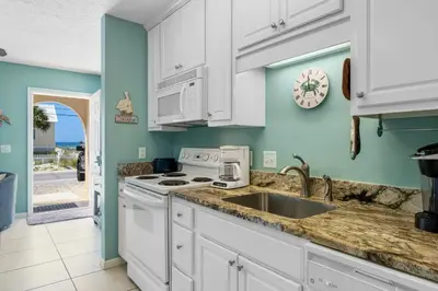 a kitchen with white cabinets and a sink at Merrimac Resort #12 in Panama City Beach