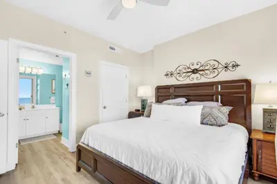 a bedroom with a large bed and a bathroom at Ocean Villa 1605 in Panama City Beach