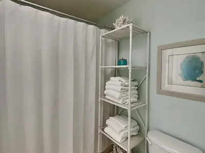 a bathroom with a white shower curtain and towels at Cassine Station 305 - Sea Ya in Santa Rosa Beach