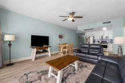 a living room with a couch and a table at Coast is Clear at Laketown Wharf #1225 by Nautical Properties in Panama City Beach